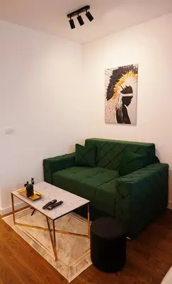 a living room with a green couch and a table at The Daily Nest in Niš