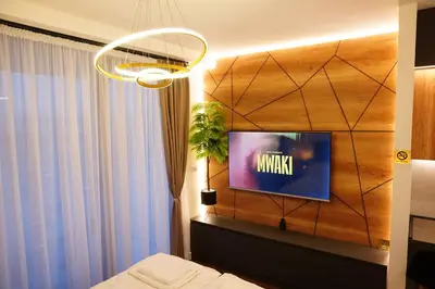 a bedroom with a tv on a wooden wall at The Daily Nest in Niš