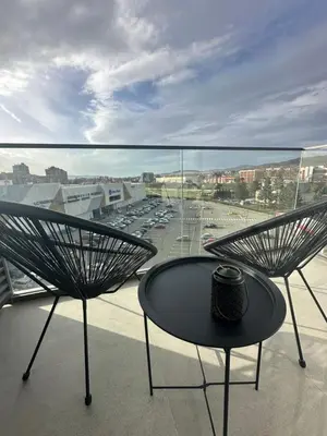 a table and chairs on a balcony with a view at The Daily Nest in Niš