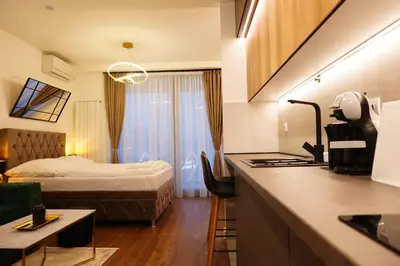a hotel room with a bed and a kitchen at The Daily Nest in Niš