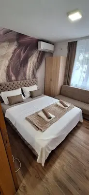 a bedroom with a large bed with a painting on the wall at Soko Bajka 1 in Soko Banja