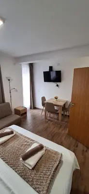 a bedroom with a bed and a dining room with a table at Soko Bajka 1 in Soko Banja