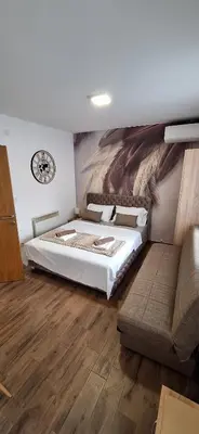a bedroom with a bed and a clock on the wall at Soko Bajka 1 in Soko Banja