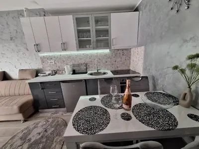 a kitchen with a table with two glasses and a bottle at Apartman MILOVANOVIĆ in Vrnjačka Banja