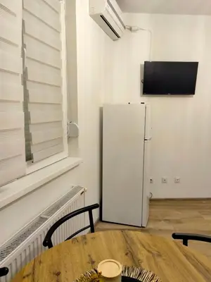 a white refrigerator in a room with a table at Apartman Nada in Jagodina