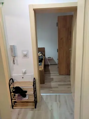 a hallway with a dog sitting on a bench next to a door at Apartman Nada in Jagodina