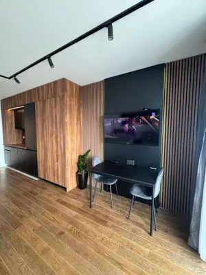 a dining room with a black table and chairs at Delta Planet Apartman in Niš