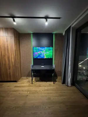 a living room with a flat screen tv on a wall at Delta Planet Apartman in Niš
