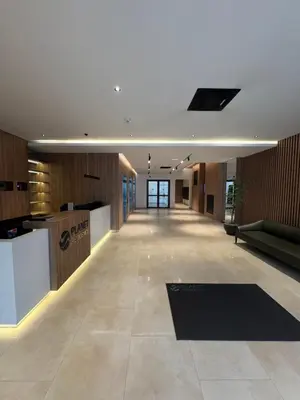 an empty lobby of an office building with a counter at Delta Planet Apartman in Niš