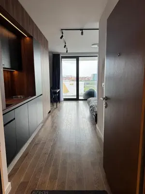 a hallway with a kitchen and a living room at Delta Planet Apartman in Niš