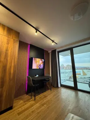 a hotel room with a table and a tv at Delta Planet Apartman in Niš