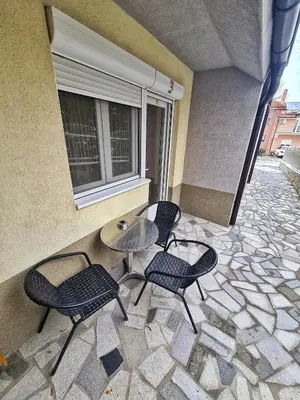 a patio with four chairs and a table and a window at Vila Aleksandra 2 studio 4 in Soko Banja