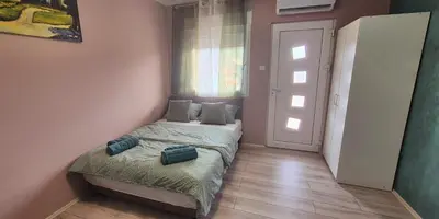 a small bedroom with a bed and a window at Apartmani IMW in Zaječar