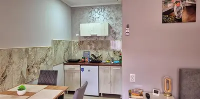 a kitchen with a table and a white refrigerator at Apartmani IMW in Zaječar