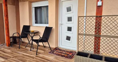 a porch with two chairs and a table next to a door at Apartmani IMW in Zaječar