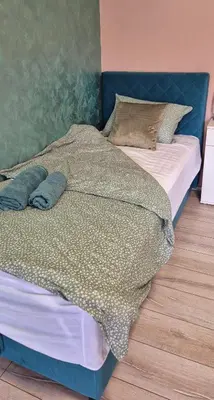 a bedroom with a large bed with a blue headboard at Apartmani IMW in Zaječar