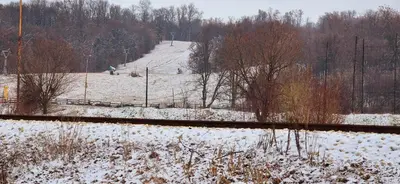 a snow covered field with a snow covered train track at Apartmani IMW in Zaječar
