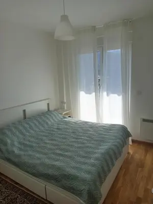 a bedroom with a bed and a large window at Ramonda apartman sa bazenom, Vrnjačka Banja in Vrnjačka Banja