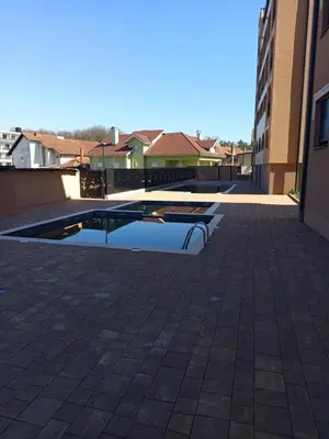 a pool in the middle of a courtyard at Ramonda apartman sa bazenom, Vrnjačka Banja in Vrnjačka Banja