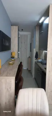 a kitchen with a counter and chairs in a room at Apartman 018 in Soko Banja