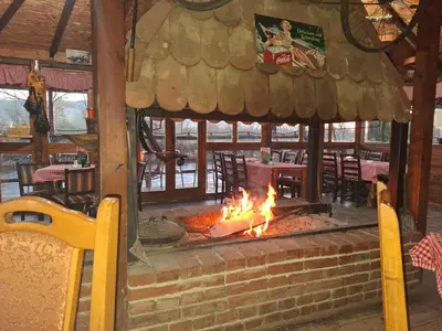 a fire pit in a restaurant with tables and chairs at Viking apartaments in Niš