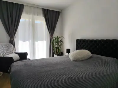 a bedroom with a large bed and a window at Apartman KUM in Vrnjačka Banja