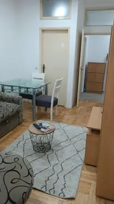 a living room with a glass table and a rug at Centar & peace in Niš