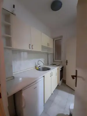 a kitchen with white cabinets and a sink at Centar & peace in Niš