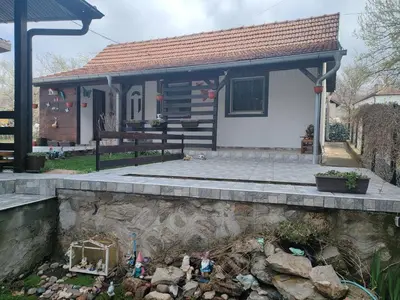 a small house with a stone wall in front of it at Miris Proleća in Rekovac