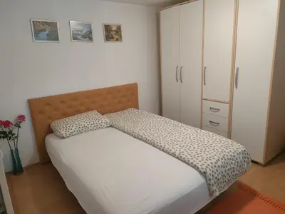 a bedroom with a bed and a white cabinet at Miris Proleća in Rekovac