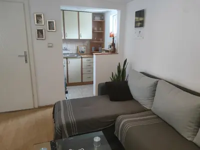 a living room with a couch and a kitchen at Miris Proleća in Rekovac
