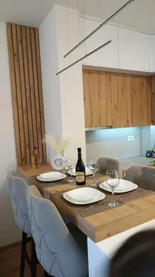 a wooden table with chairs and a bottle of wine at Apartman Jana in Vrnjačka Banja
