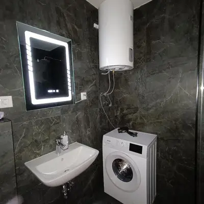 a bathroom with a washing machine and a sink at Apartman Jana in Vrnjačka Banja