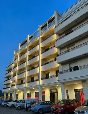 a large building with cars parked in front of it at Apartman Jana in Vrnjačka Banja
