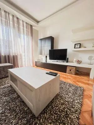 a living room with a large bed in a room at Elena apartman in Vranje