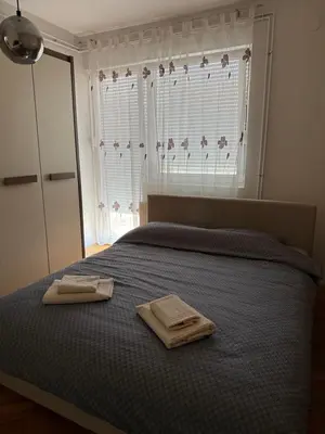 a bedroom with a bed with two towels on it at Elena apartman in Vranje
