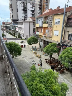 a view of a city street with people and benches at Elena apartman in Vranje