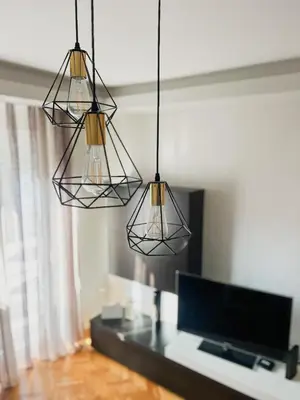 a living room with three lights hanging from the ceiling at Elena apartman in Vranje
