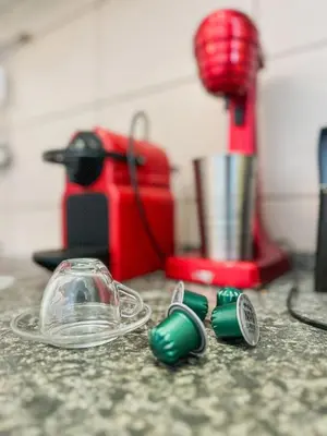 a counter top with a blender and green dishes at Elena apartman in Vranje