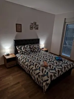 a bedroom with a bed and two lamps and a window at Apartman Moj kutak 29 in Vrnjačka Banja