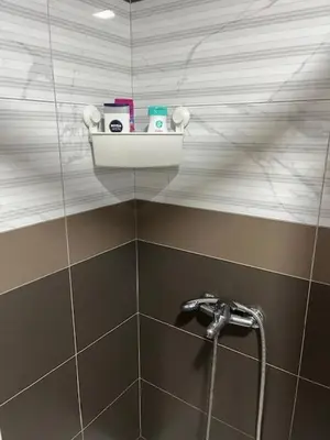 a bathroom with a shower with a shelf on the wall at Apartman Moj kutak 29 in Vrnjačka Banja