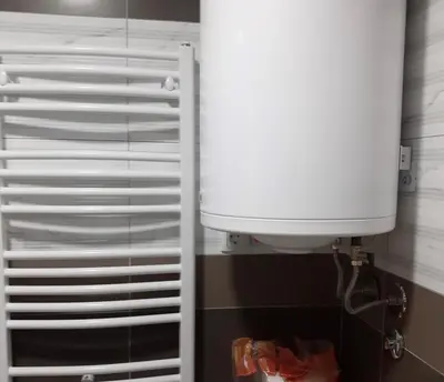 a white toilet in a bathroom with a water tank at Apartman Moj kutak 29 in Vrnjačka Banja