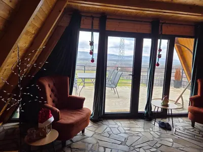a living room with a chair and a large window at Vezirove zore in Paraćin