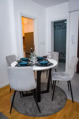 a white dining room table with blue plates and chairs at Sunčani Horizonti in Soko Banja
