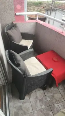 a balcony with two chairs and a red table at Agape in Niš
