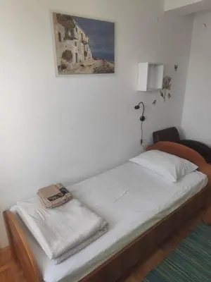 a bed in a room with a picture on the wall at Agape in Niš