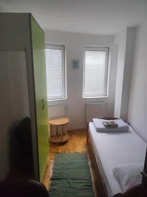 a small room with a bed and a table at Agape in Niš