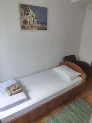 a bed in a room with a painting on the wall at Agape in Niš