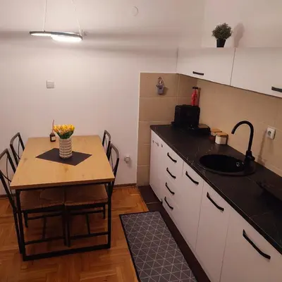 a kitchen with a table and a small table with chairs at Banjski apartman in Vrnjačka Banja