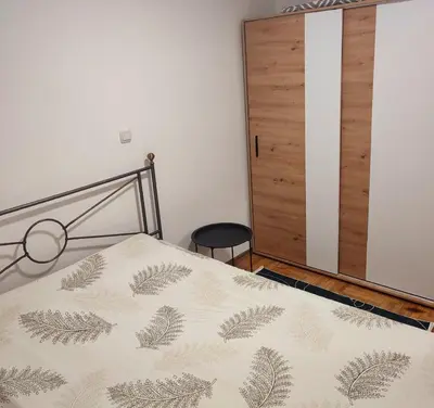 a bedroom with a bed and a wooden door at Banjski apartman in Vrnjačka Banja